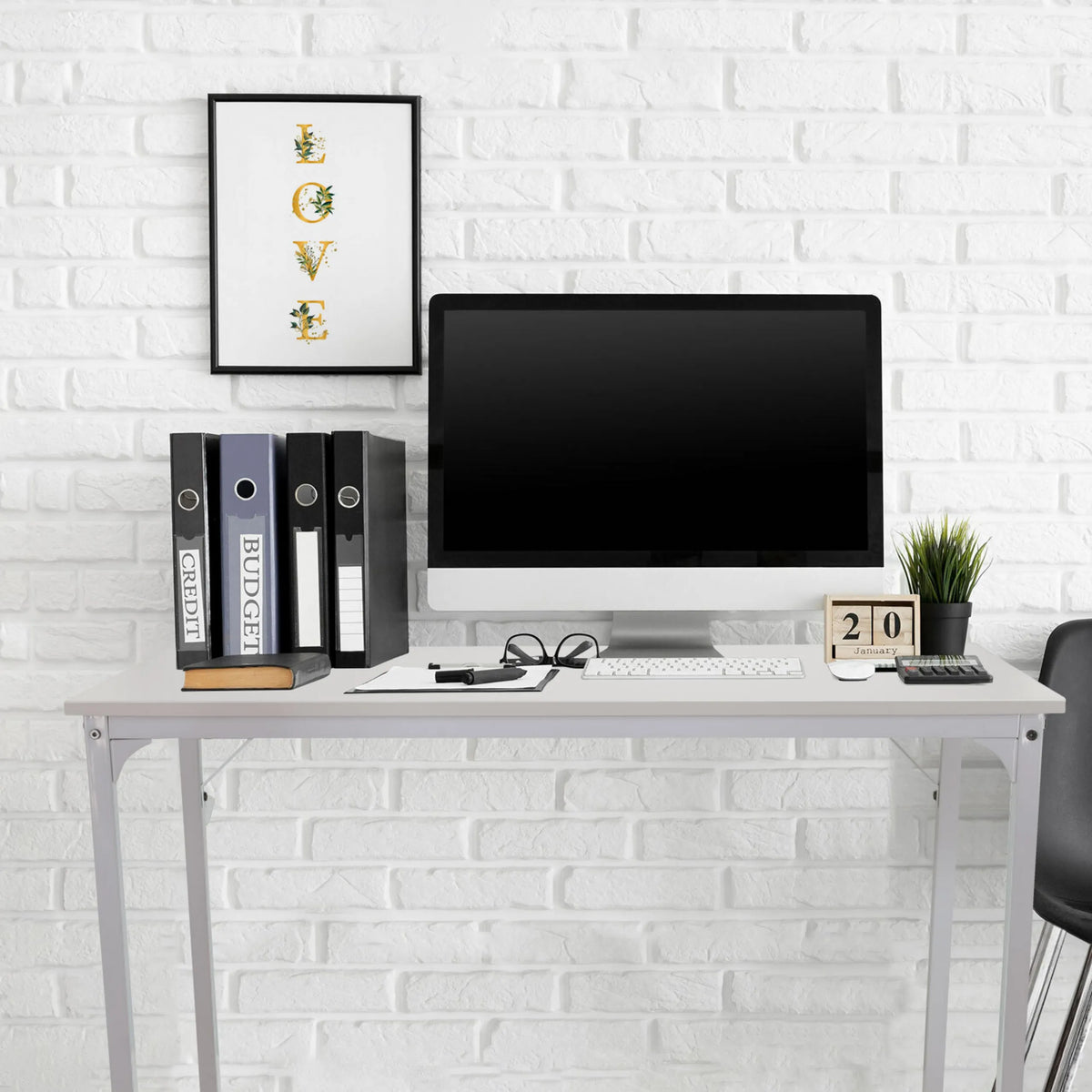Escritorio blanco WORKSPACE I de 100 × 50 cm frente a una pared de ladrillo blanco de hjh OFFICE