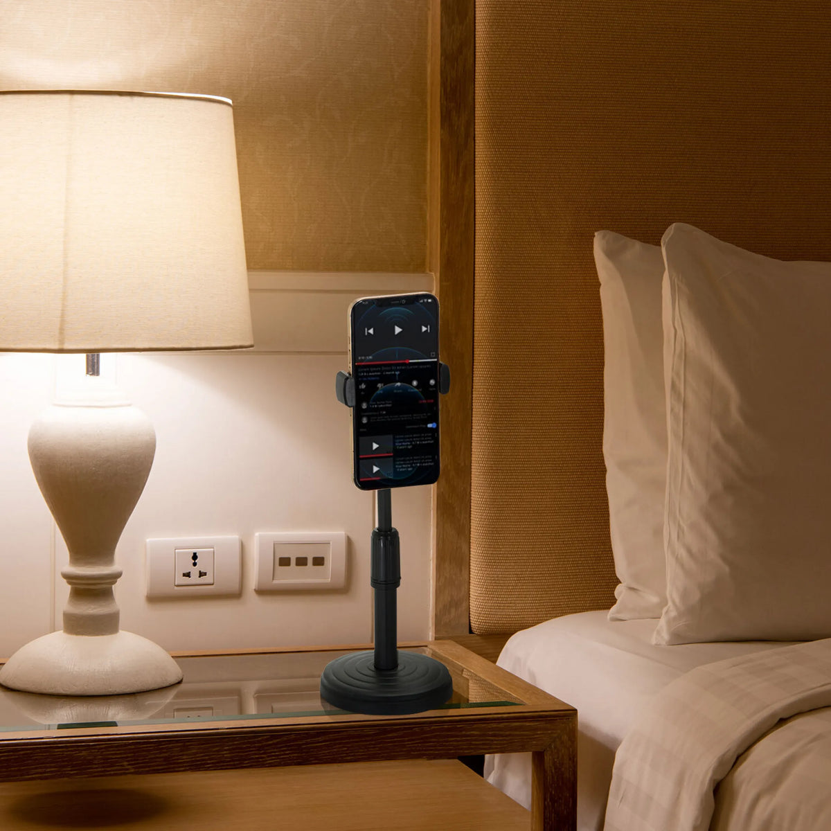 Soporte para teléfono móvil y tableta FLEXMOBI II negro con un smartphone sobre una mesita de noche de hjh OFFICE