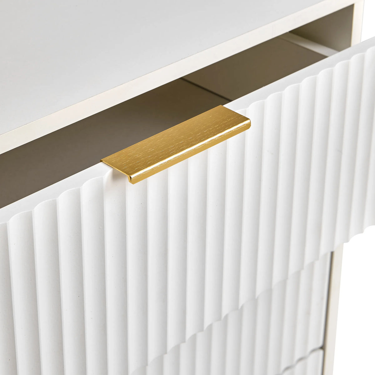 Tirador dorado en un frente blanco con estructura acanalada de la cómoda Hjelle K de hjh LIVING