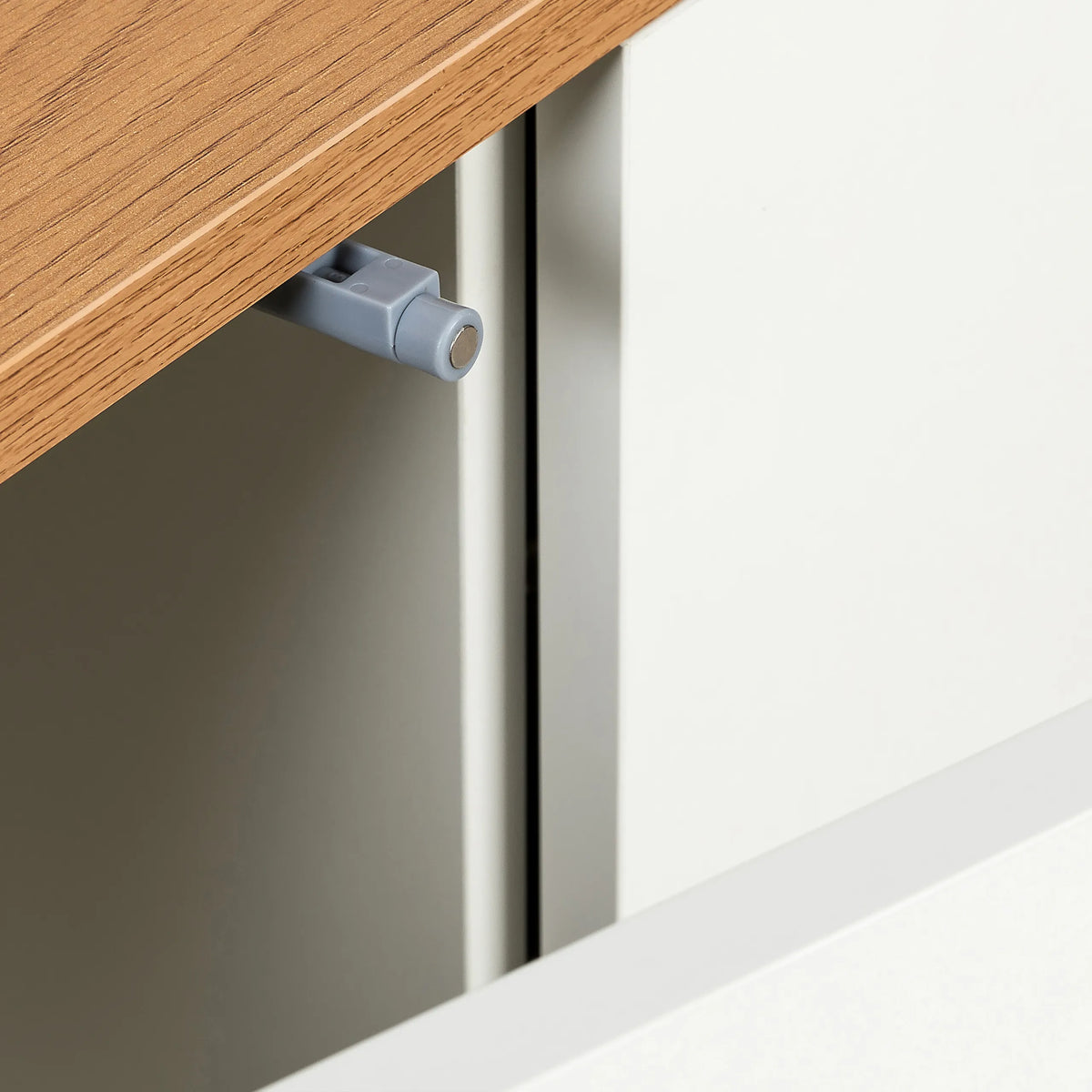 Tope de puerta gris en la superficie color roble del aparador KELO S de hjh LIVING