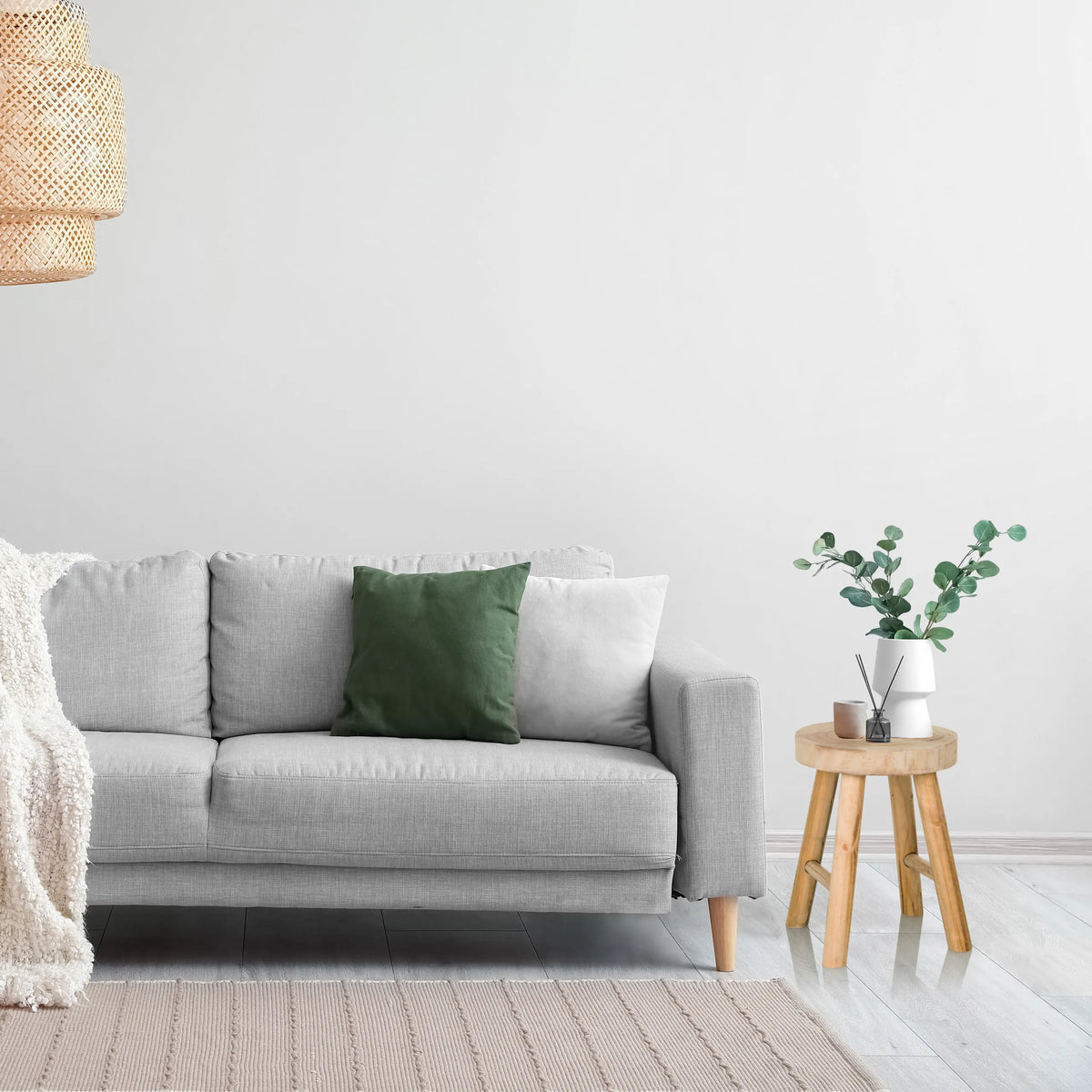 Taburete de madera marrón RUSTIKO W como mesa auxiliar junto a un sofá gris de hjh LIVING