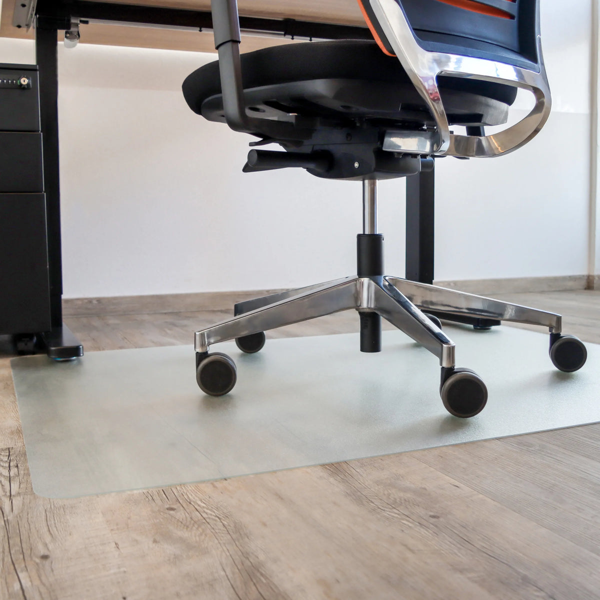 Alfombrilla PUNOMAT transparente para suelos duros debajo de una silla de oficina de Kottig