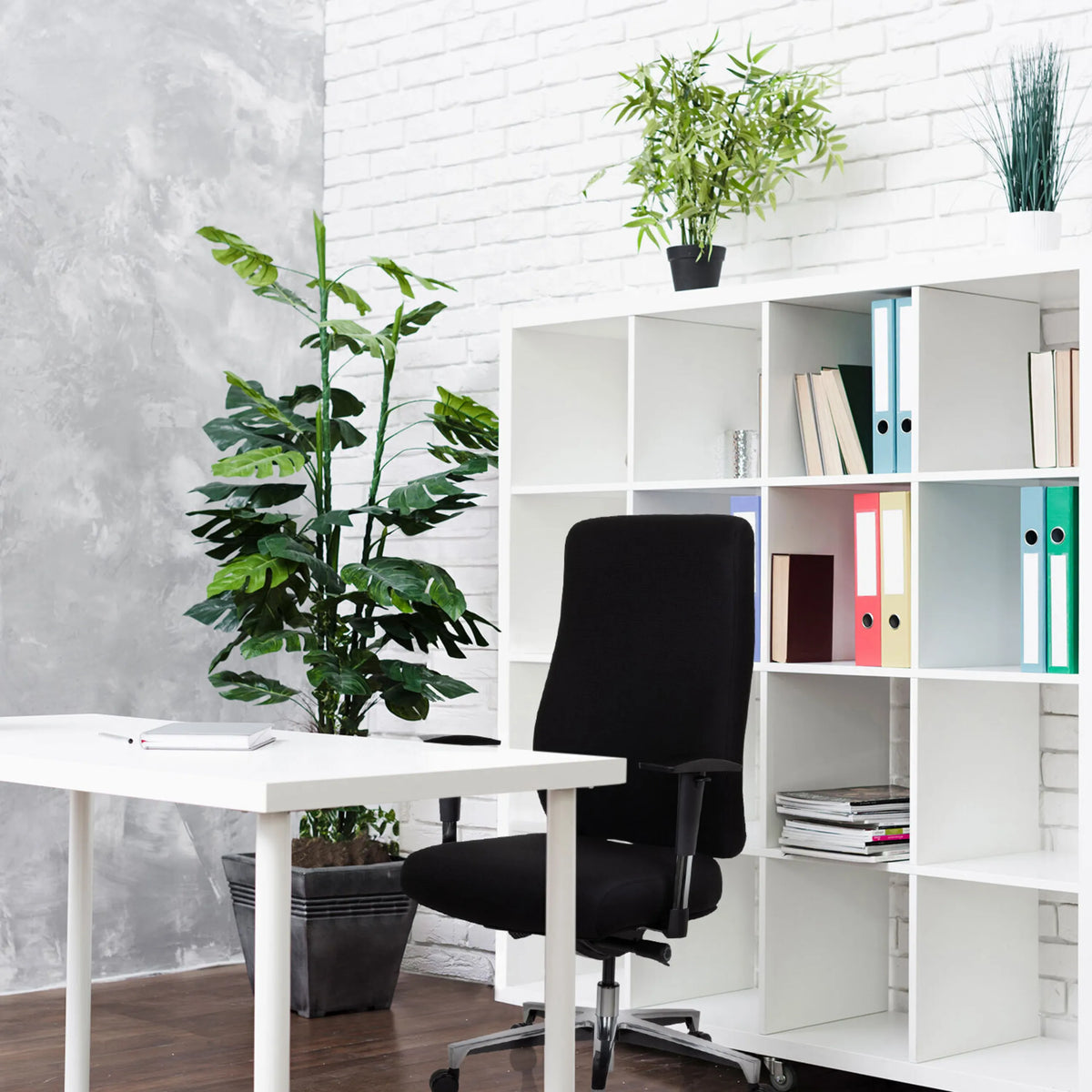 Silla de oficina profesional FORCOM negra delante de una estantería blanca y un escritorio blanco de hjh OFFICE