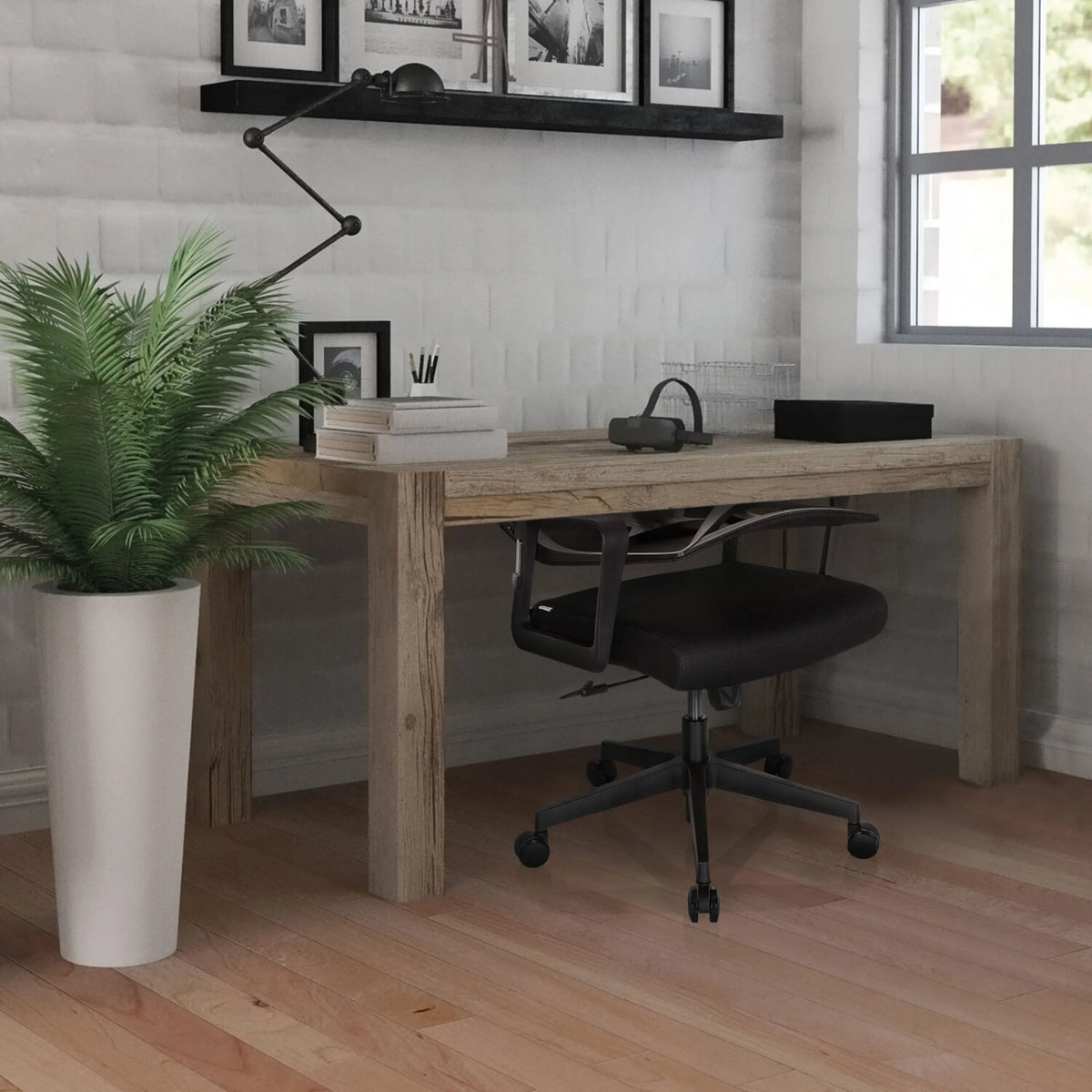 Silla Home Office ENCO negra en una mesa de madera en una habitación iluminada de hjh OFFICE