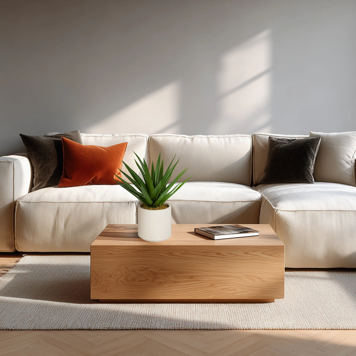 Planta artificial Agave en verde con maceta blanca sobre una mesa de madera frente a un sofá claro de hjh OFFICE