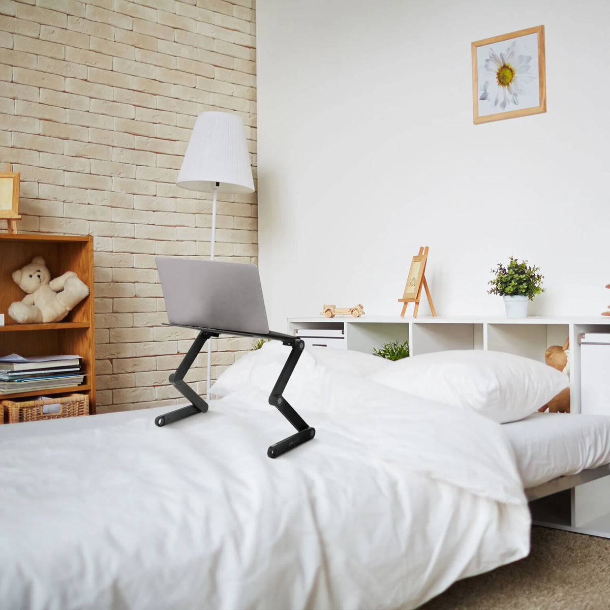 Soporte de escritorio VM-SA II negro con un portátil sobre una cama en una habitación luminosa de hjh OFFICE