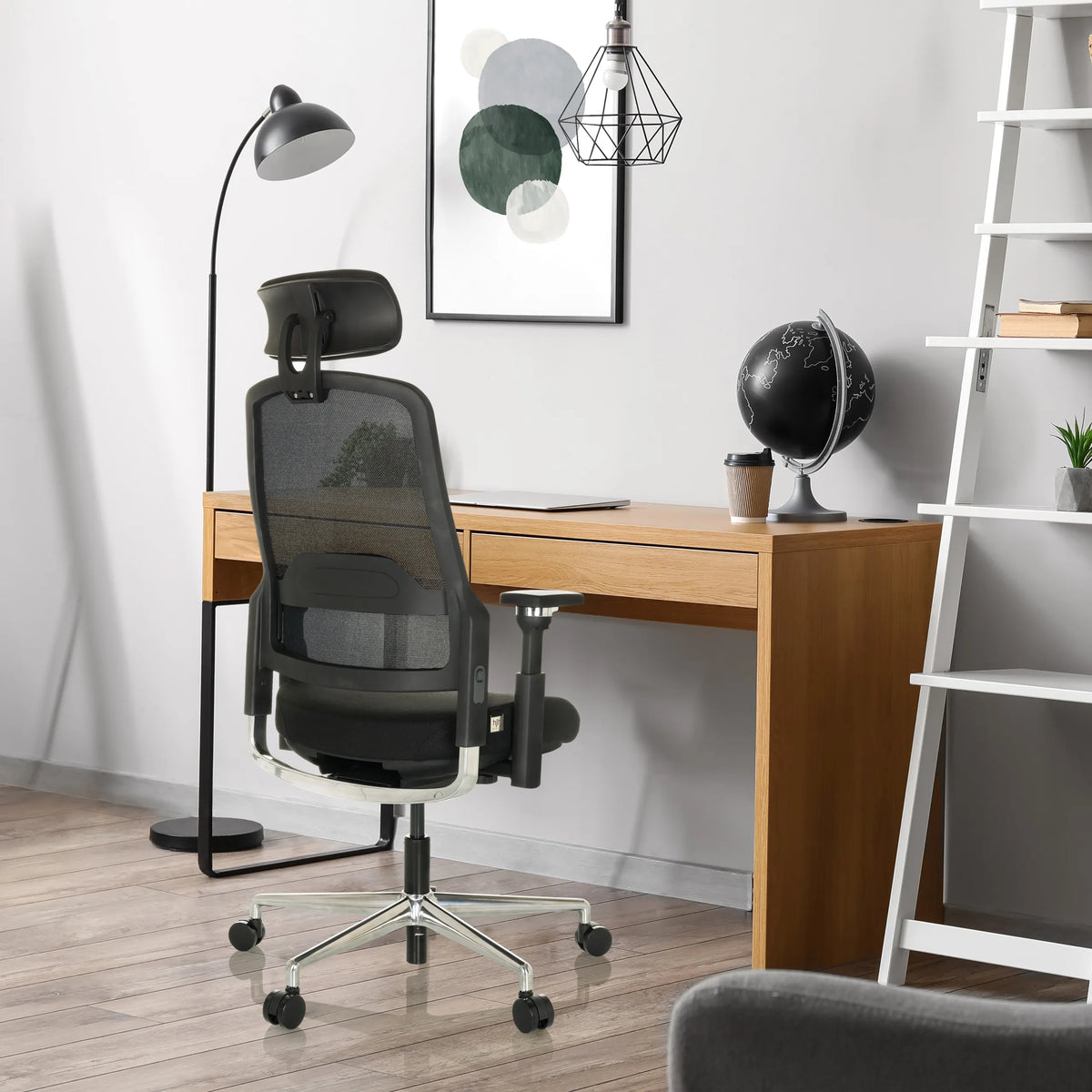 Silla de oficina profesional TERARO AX negra con respaldo de malla y reposacabezas delante de un escritorio de hjh OFFICE