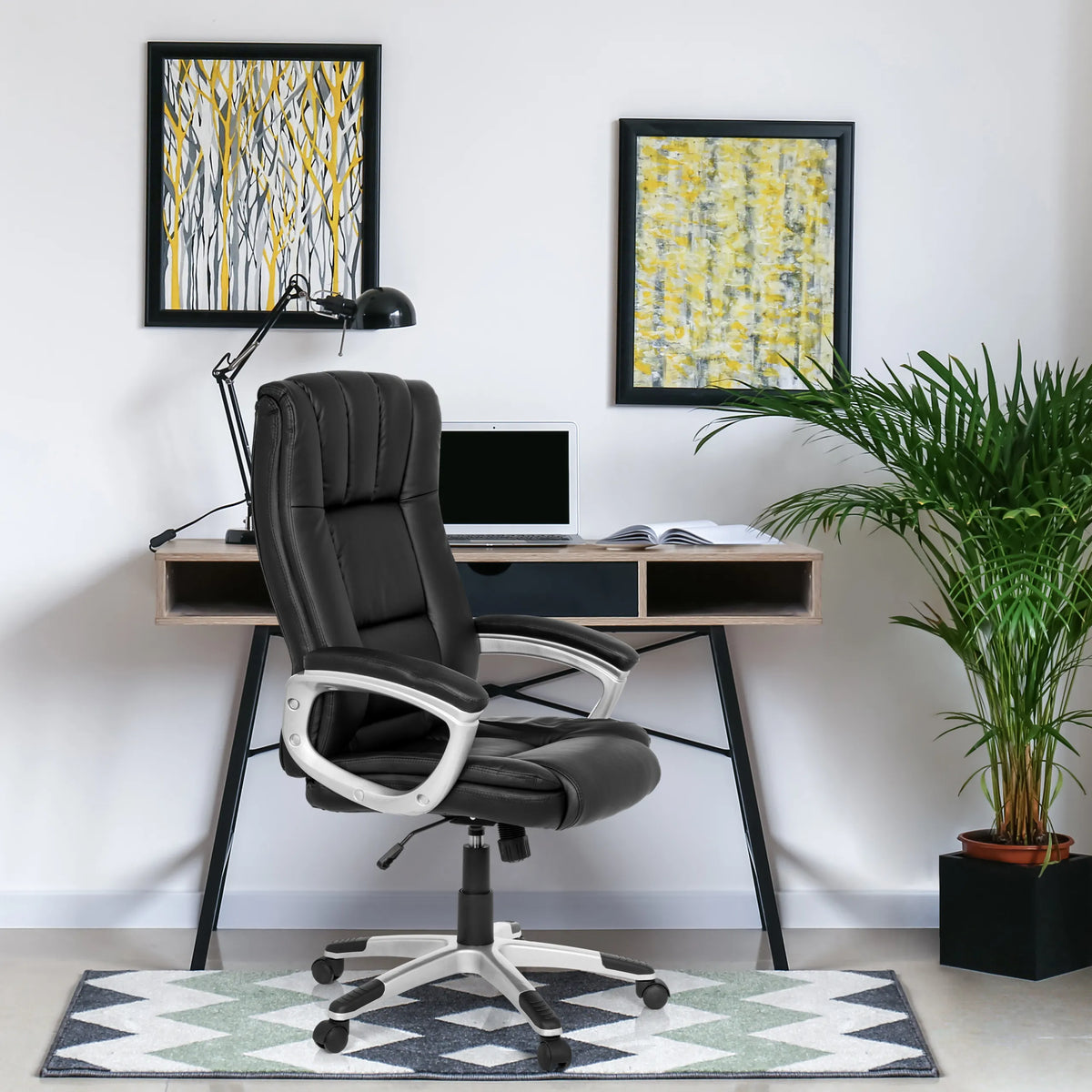 Silla Home Office RELAX CL150 negra con reposabrazos y ruedas delante de un escritorio de MyBuero