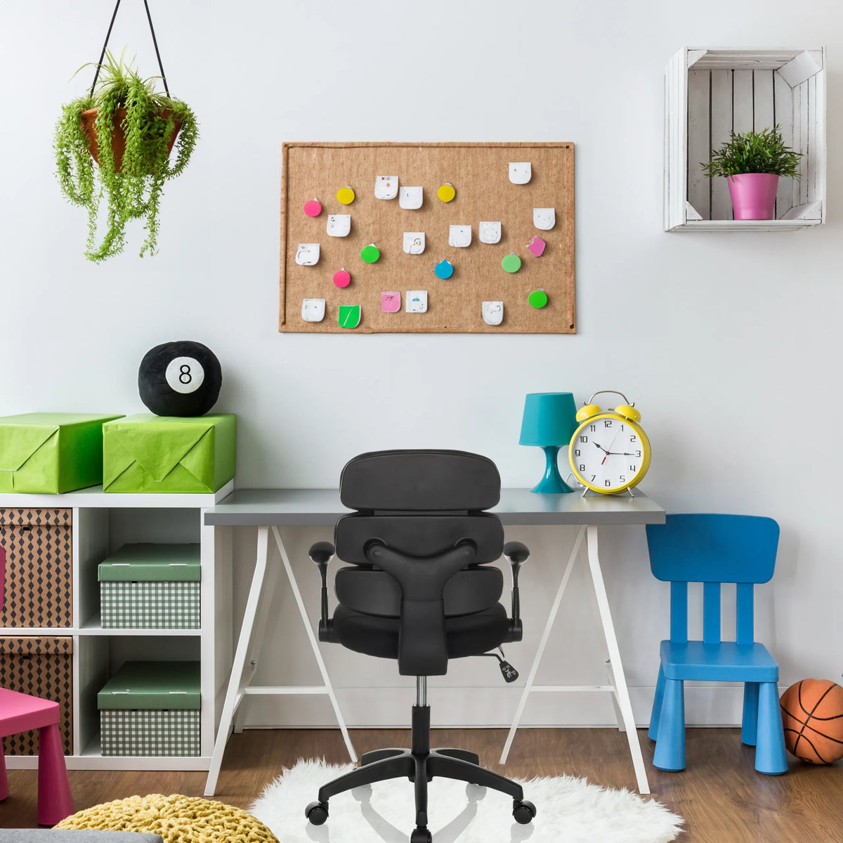 Silla giratoria para niños KID ERGOLINO B negra con reposabrazos y ruedas delante de un escritorio de hjh OFFICE