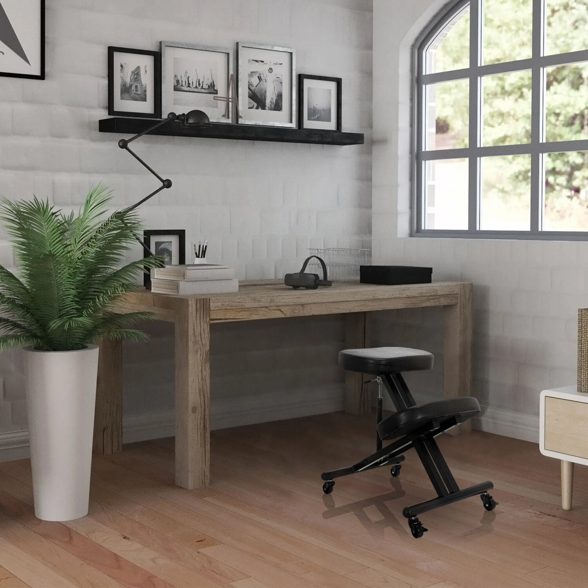 Silla ergonómica de rodillas ORTHONI negra con ruedas delante de un escritorio de madera en una habitación iluminada de hjh OFFICE