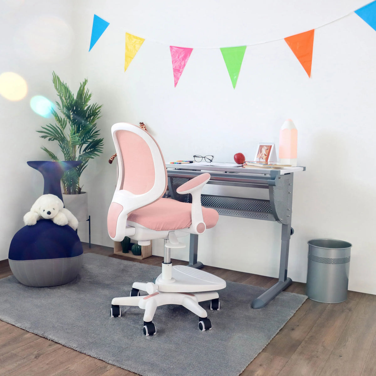 Silla para niños rosa KID ERGO con reposabrazos blancos y ruedas en un escritorio de hjh OFFICE