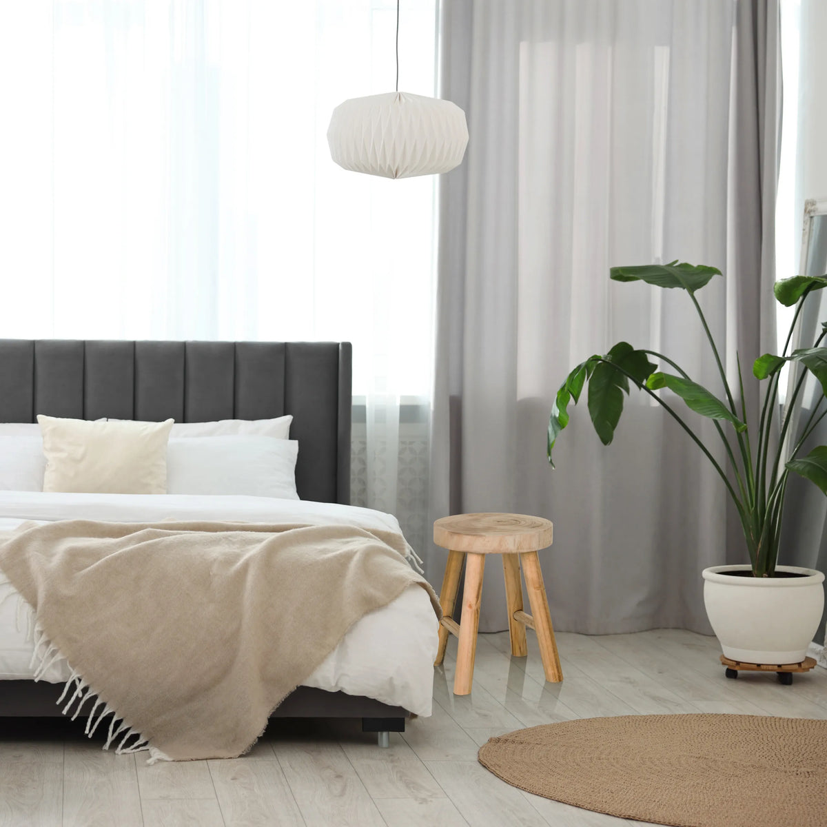 Taburete RUSTIKO W de madera marrón con tres patas junto a una cama de hjh LIVING
