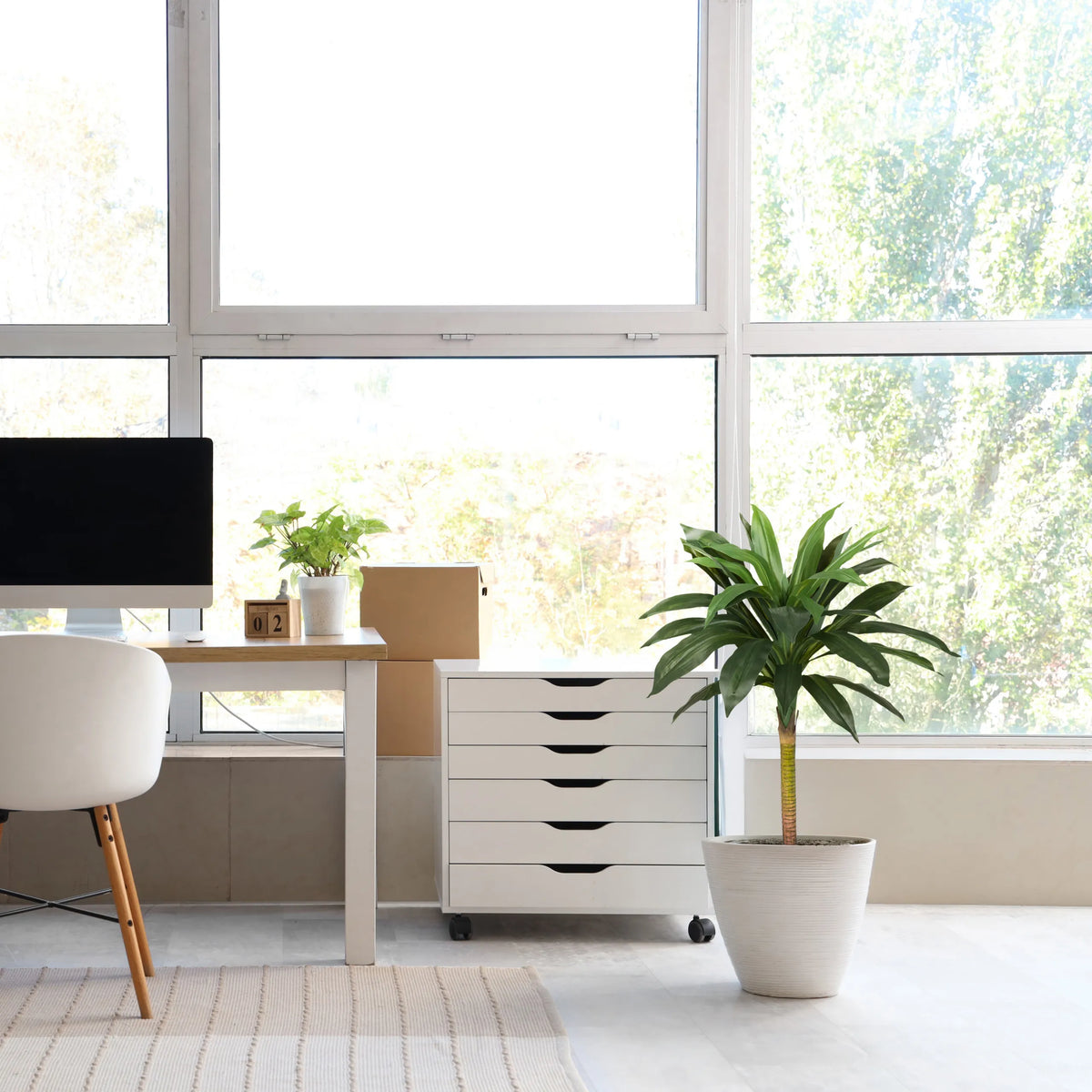Planta artificial DRACAENA I en verde con una maceta exterior blanca en una habitación luminosa de hjh OFFICE