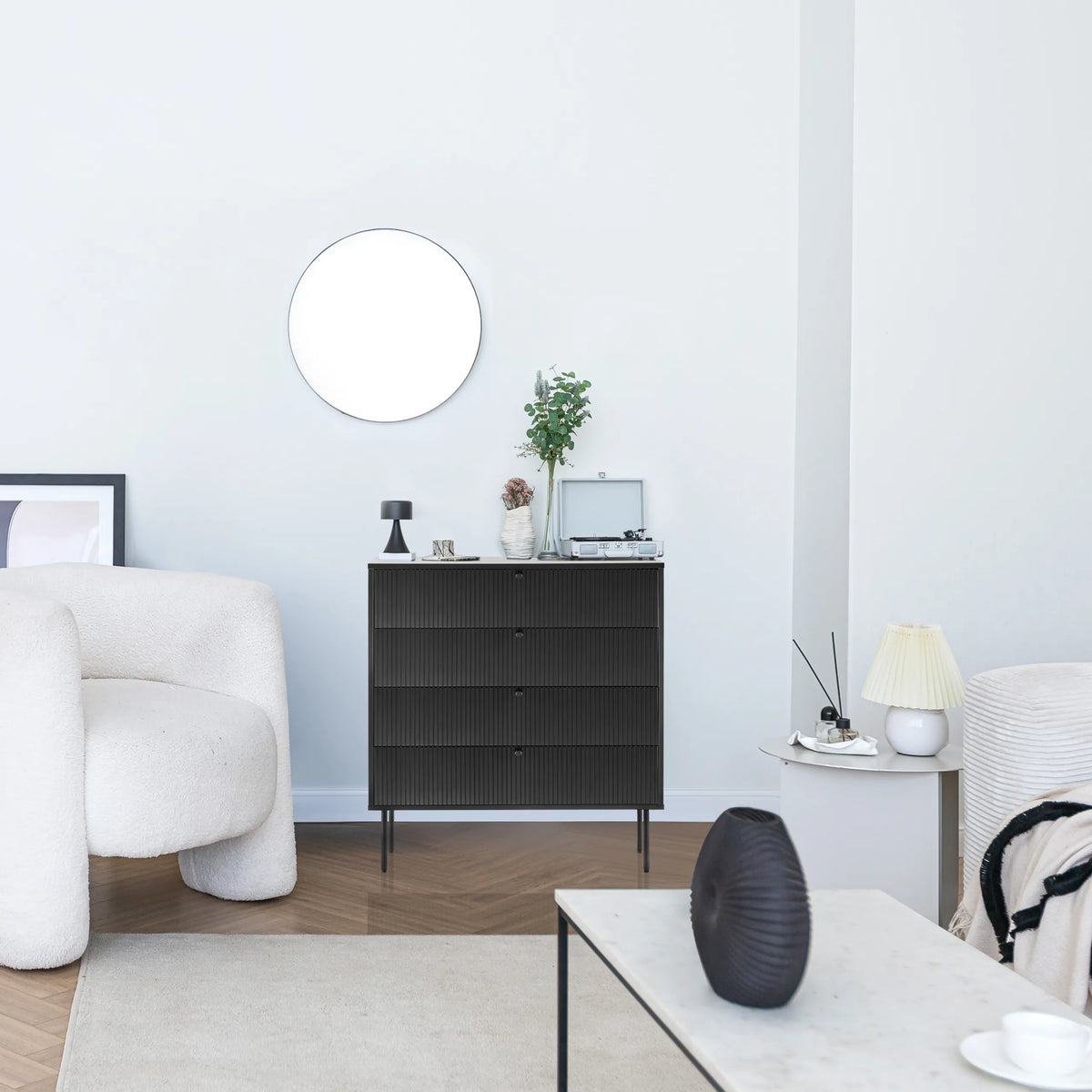 Cómoda negra KARBY K con tres cajones y patas metálicas delgadas en una sala de estar luminosa de hjh LIVING