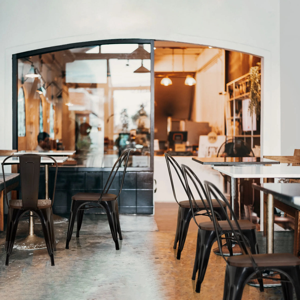 Sillas de comedor negras VANTAGGIO COMFORT W con estructura metálica en mesas de una cafetería de hjh OFFICE