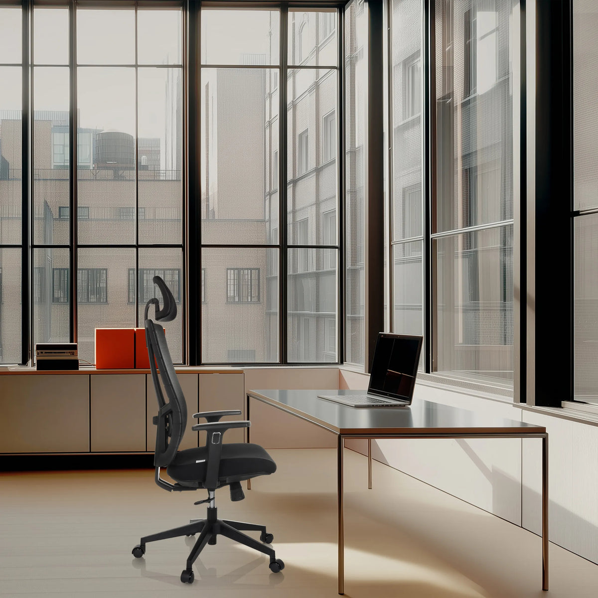 Silla de oficina profesional TRAMORE negra con reposacabezas y reposabrazos en un escritorio frente a una ventana de hjh OFFICE