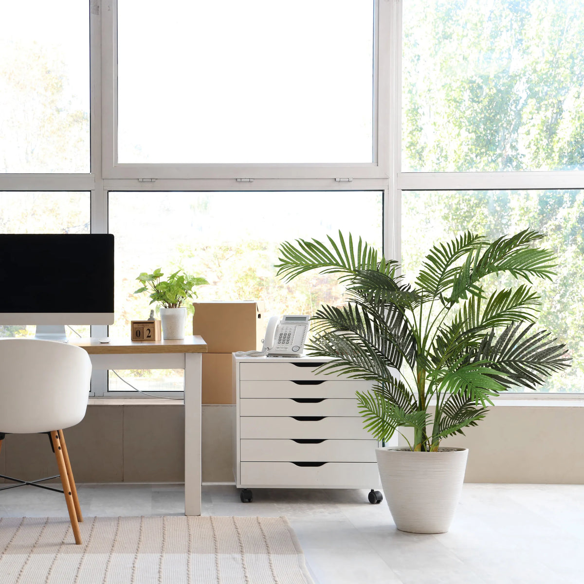 Planta artificial verde ARECA II en una maceta blanca junto a un contenedor con ruedas blanco de hjh OFFICE