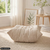 Puf Sitzolo Podi beige con estructura acolchada sobre una alfombra clara de hjh LIVING (imagen generada por IA)