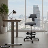 Silla de trabajo TOP WORK 40 gris oscuro con anillo para los pies y ruedas delante de una ventana de hjh OFFICE (imagen generada por IA)