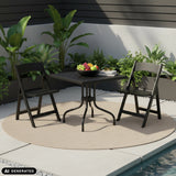 Mesa plegable TRAVANO T1 negra con dos sillas plegables a juego en el exterior de hjh LIVING (imagen generada por IA)