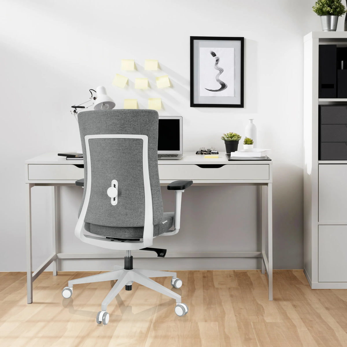 Silla de oficina profesional COMFIO WP en color gris con estructura y ruedas blancas frente a un escritorio de hjh OFFICE