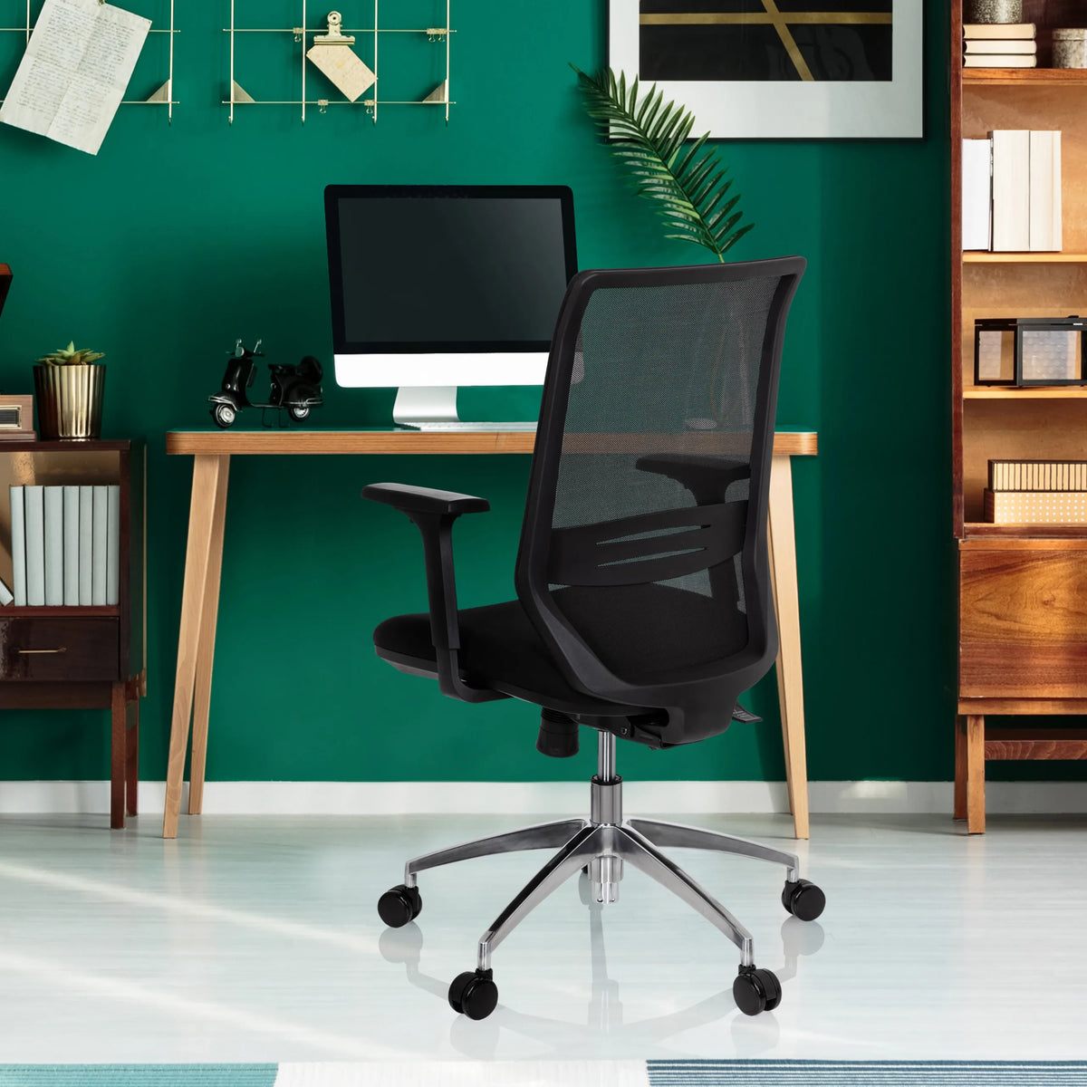 Silla de oficina profesional PROFONDO negra con respaldo de malla y base cromada delante de un escritorio de hjh OFFICE