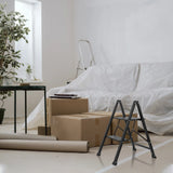 Escalera plegable negra SOLID W5 de dos peldaños en una habitación con cajas de mudanza de hjh OFFICE