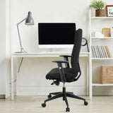 Silla de oficina profesional PRO-TEC 300 negra con reposabrazos y ruedas en un escritorio blanco de hjh OFFICE
