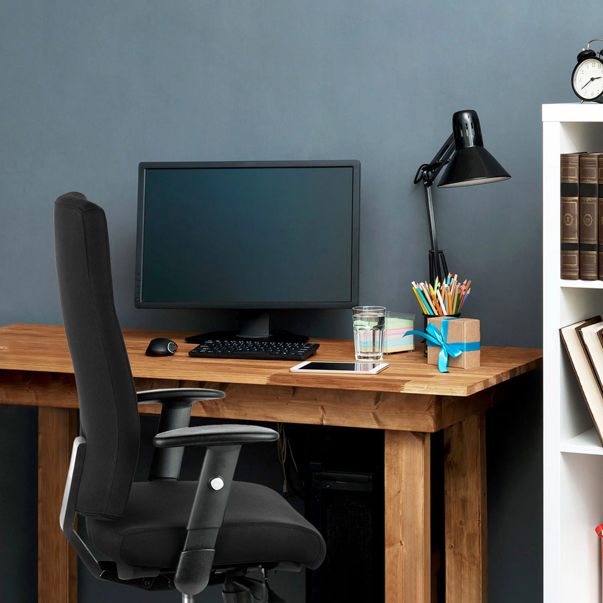 Silla de oficina profesional PRO-TEC 300 negra con reposabrazos en una mesa de madera de hjh OFFICE