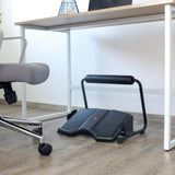 Reposapiés PODI F negro con pedal antideslizante y barra transversal acolchada bajo un escritorio de hjh OFFICE