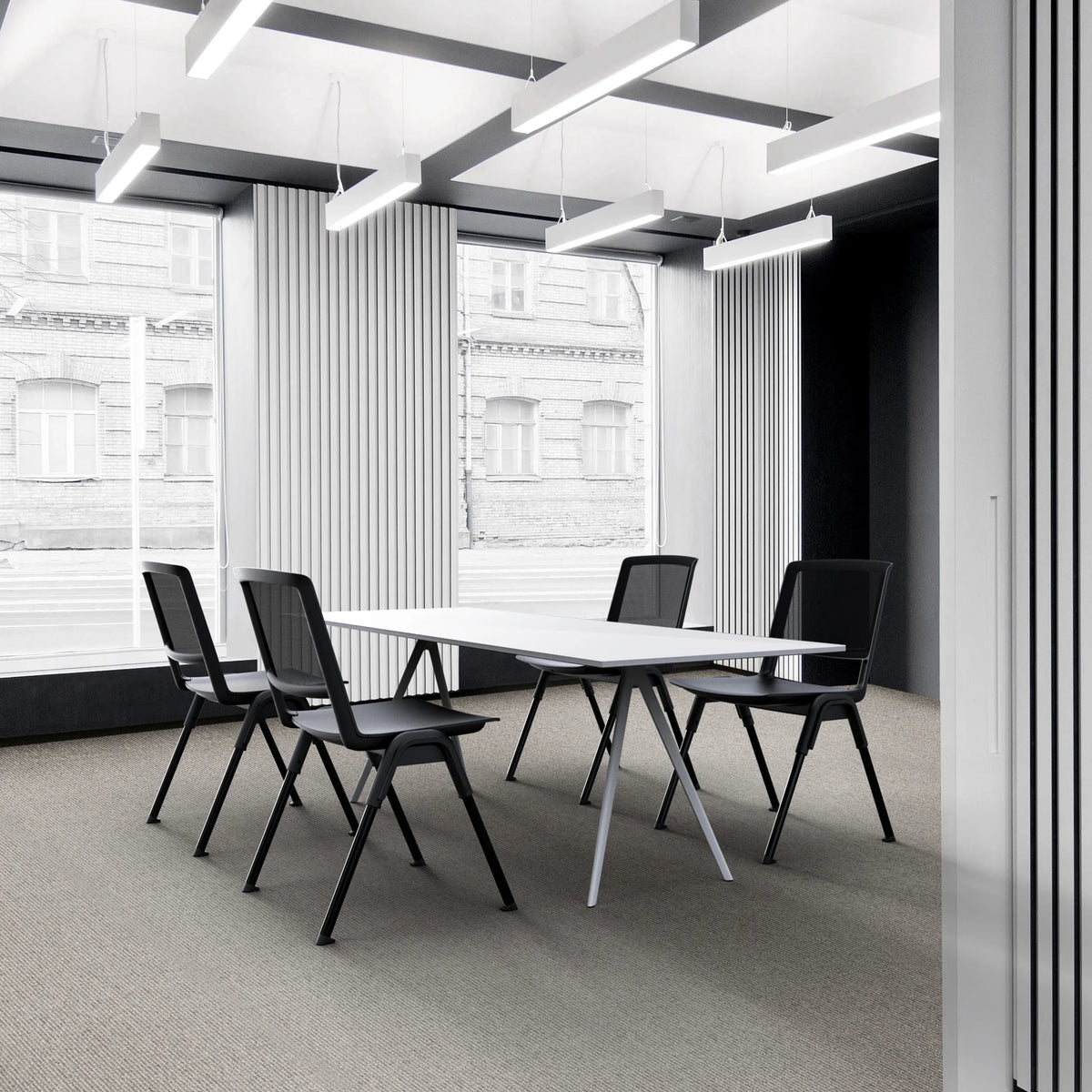 Cuatro sillas de confidente MEET WA negras en una mesa de conferencias blanca en una oficina moderna de hjh OFFICE