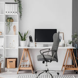 Silla Home Office ARTON 40 gris con reposabrazos y ruedas delante de un escritorio de hjh OFFICE