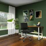 Silla de oficina profesional TRISHA en negro con efecto de costura acolchada y ruedas delante de un escritorio de hjh OFFICE