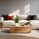 Planta artificial Agave en verde con maceta blanca sobre una mesa de madera frente a un sofá claro de hjh OFFICE