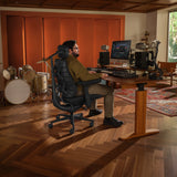 Silla de oficina LiberNovo Maxis Airflow en grafito en un escritorio regulable en altura en un estudio de música de Libernovo