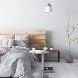 Escritorio de pie blanco STAND III con tablero redondo junto a una cama de hjh OFFICE
