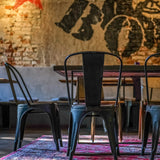 Vista trasera de una silla de comedor VANTAGGIO BRUSH de metal negra junto a una mesa de hjh OFFICE
