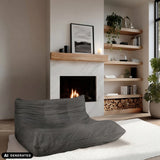 Sillón de diseño Sitzolo 2 gris frente a una chimenea de hjh LIVING (imagen generada por IA)