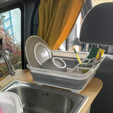 Contenedor plegable CLEAN SIL en gris y blanco con vajilla y cubiertos sobre una encimera de hjh OFFICE