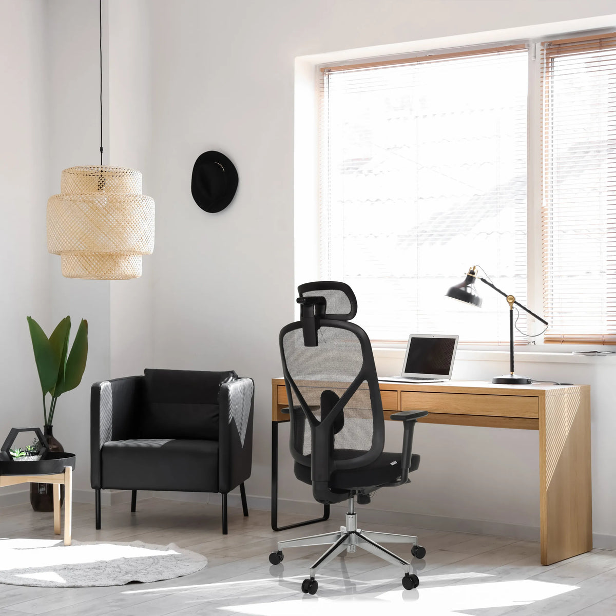 Silla de oficina profesional RALOO PRO en negro con respaldo de malla y reposacabezas en un escritorio de hjh OFFICE