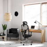 Silla de oficina profesional RALOO PRO en negro con respaldo de malla y reposacabezas en un escritorio de hjh OFFICE