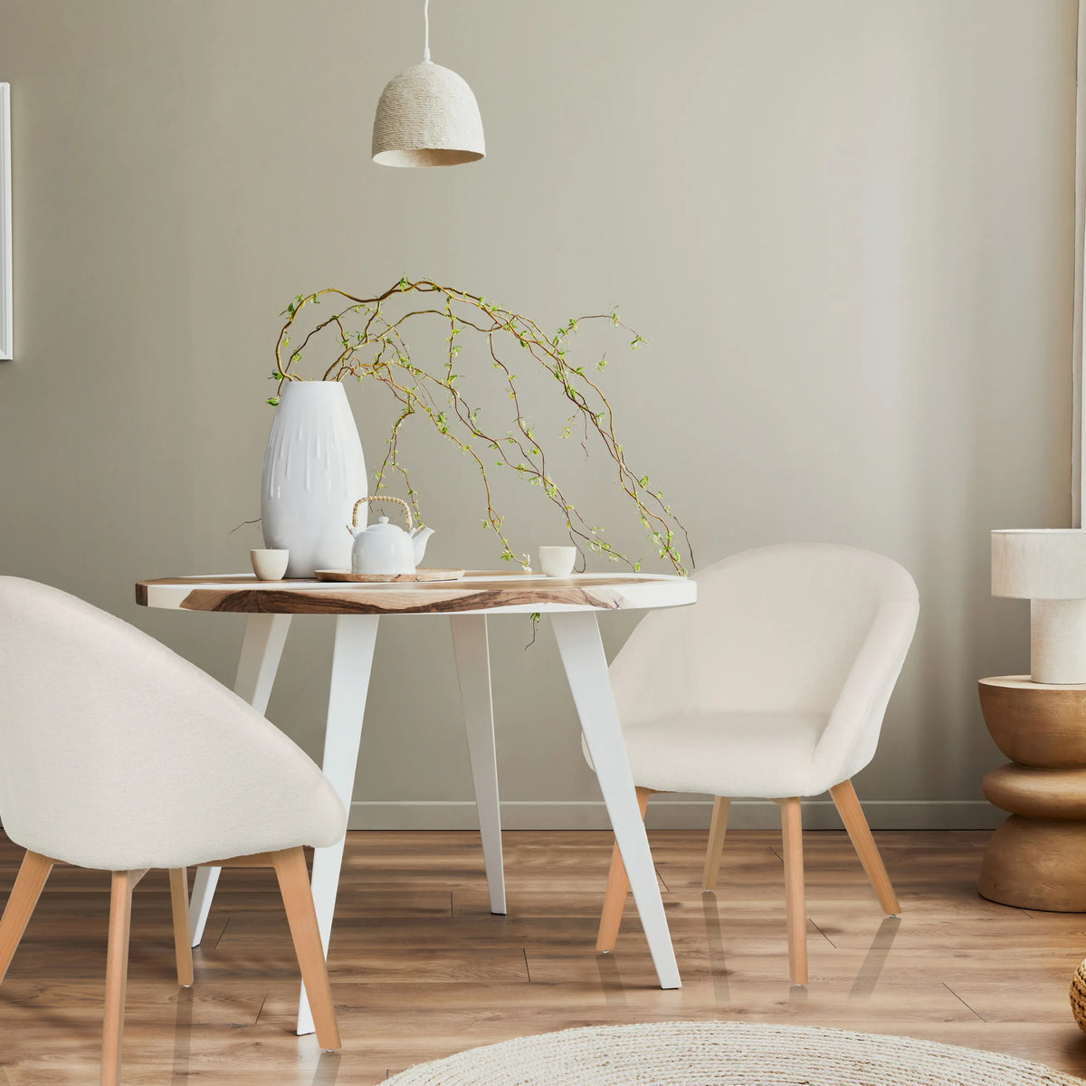 Dos sillas tapizadas blancas SCANDI TED con patas de madera clara en una mesa redonda de hjh LIVING
