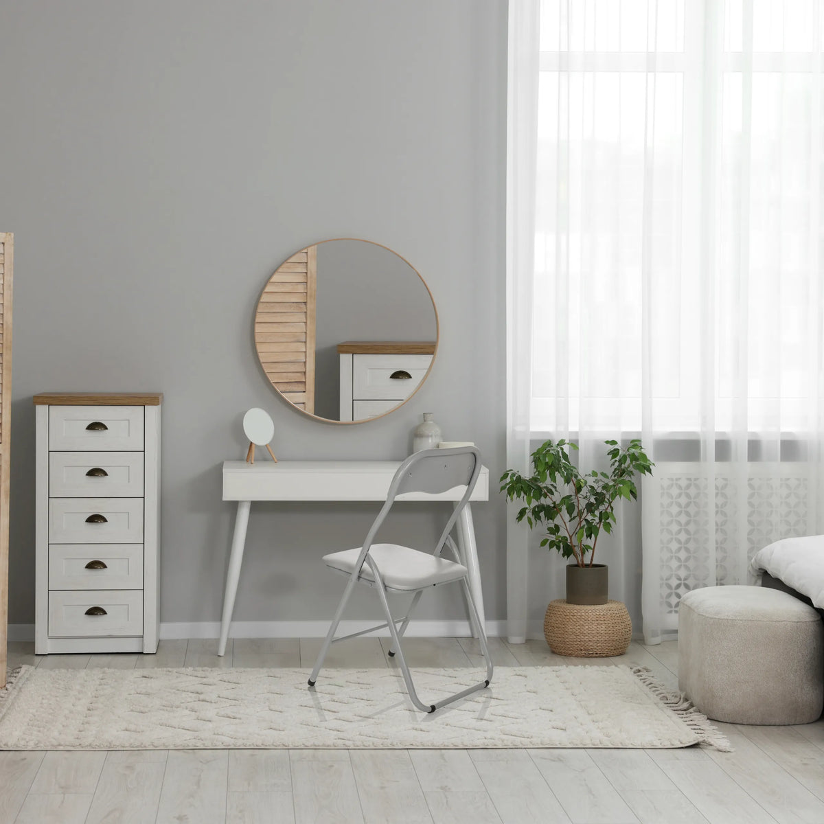 Silla plegable TUDELA BASIC gris de PVC en una habitación luminosa con un tocador blanco de hjh OFFICE