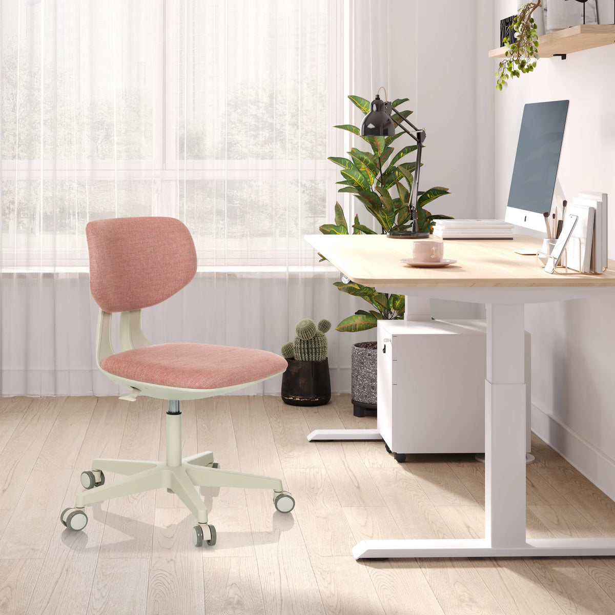 Silla giratoria para niños KID CLASSIC en color rosa con estructura blanca y ruedas en un escritorio claro de hjh OFFICE