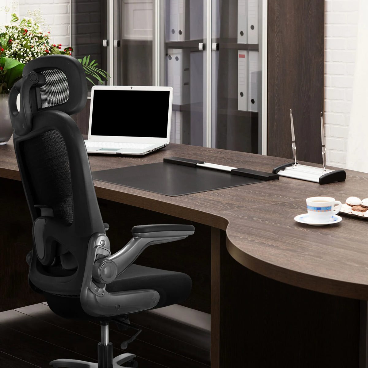 Silla giratoria XXL INSTRUCTOR T I PRO en negro con respaldo de malla en un escritorio oscuro de hjh OFFICE