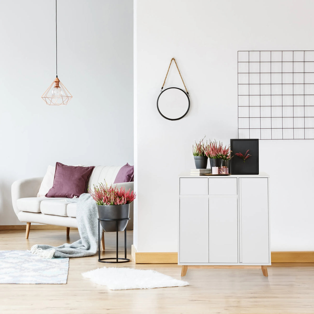 Cómoda blanca ESTHA con dos puertas y patas de madera clara en un salón luminoso de hjh LIVING