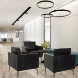 Tres sillones de diseño BAVERO negros de cuero sintético en una zona de descanso de oficina moderna de hjh OFFICE