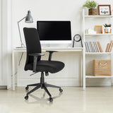 Silla Home Office COSIO I negra con reposabrazos y ruedas en un escritorio blanco de hjh OFFICE