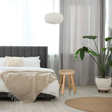 Taburete RUSTIKO W de madera marrón con tres patas junto a una cama de hjh LIVING