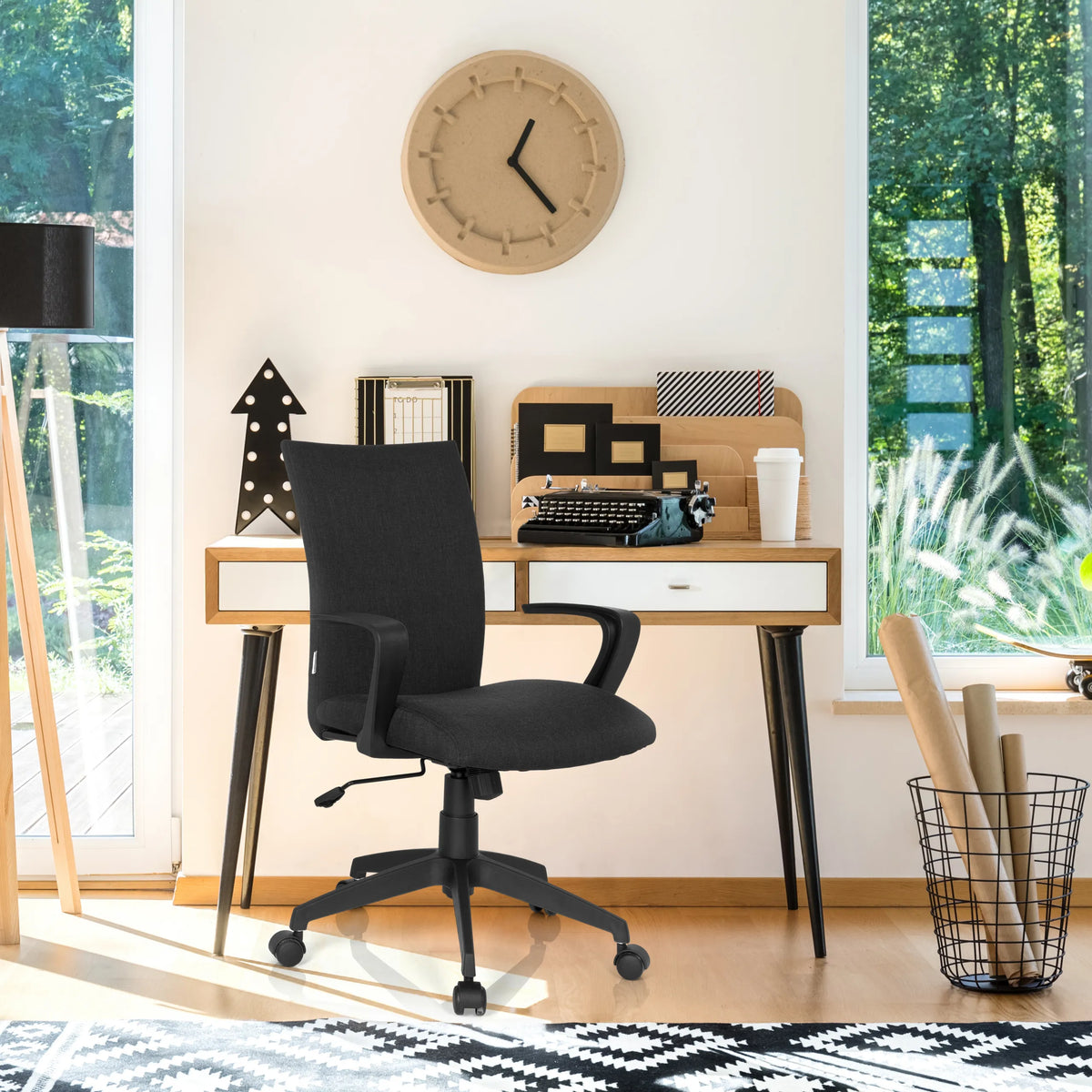 Silla Home Office SOFT negra con reposabrazos y ruedas delante de un escritorio de hjh OFFICE